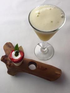 Van het huis: gin fizz met perzik. Amuse: uitgeholde aardbei met kokosmelk en munt.