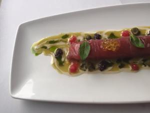 Cannelloni van tonijn gevuld met tartaar van tonijn, saus van olijfolie, tomaat, kappers, kaviaar van olijfolie, limoen en basilicum.